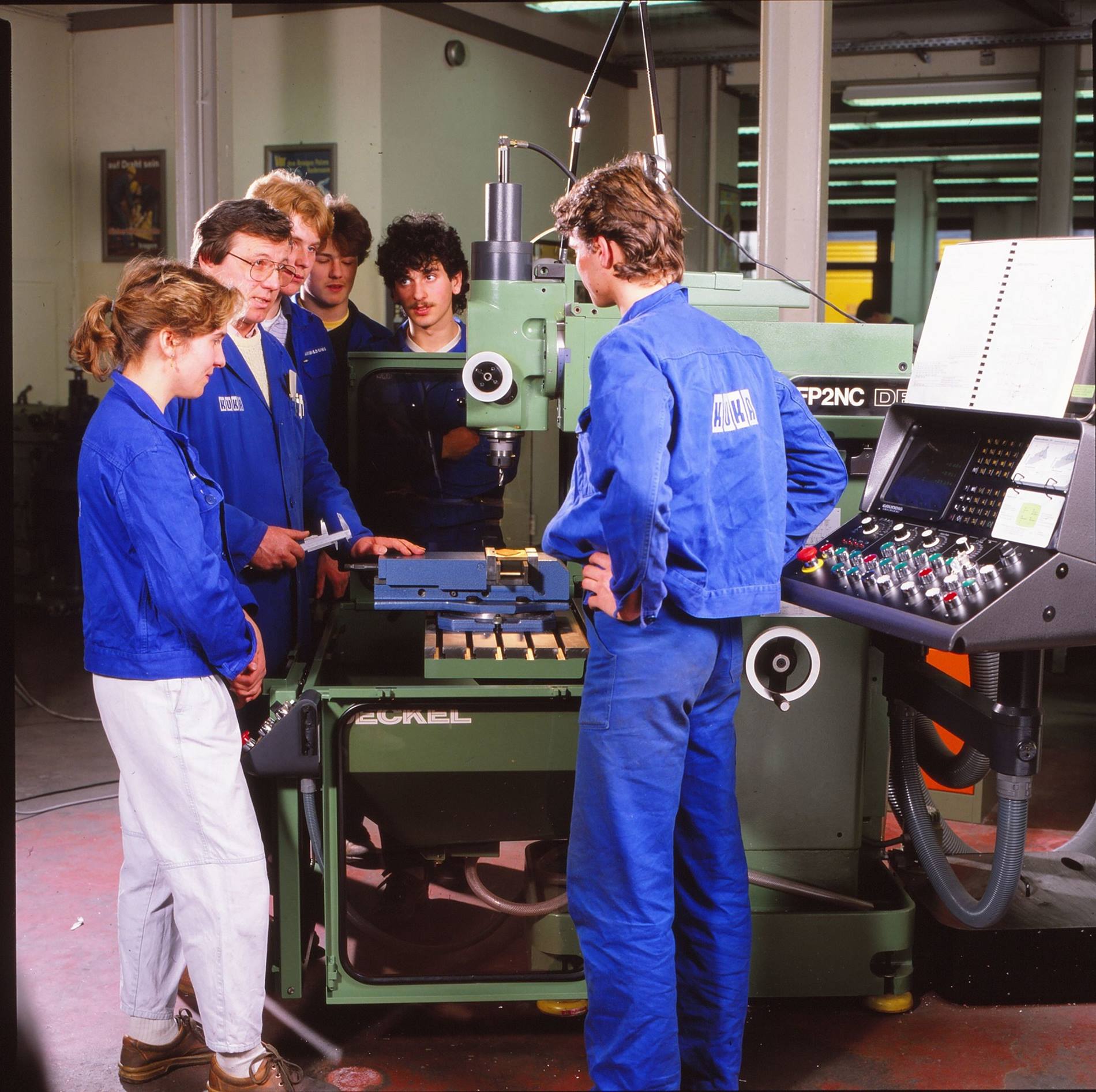 Ausbildung bei KUKA im Jahr 1987: Ein Ausbilder und fünf Auszubildende stehen vor einer Fräsmaschine. Beim Augsburger Automatisierungsspezialisten wird bereits seit über einhundert Jahren ausgebildet. 