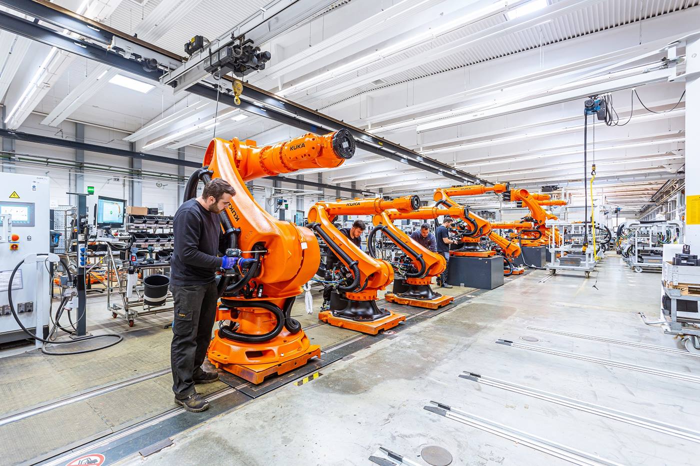 Ein Blick in die Werkshallen der Roboterproduktion bei KUKA in Augsburg: Ein Mitarbeitender montiert einen KUKA Roboter. 