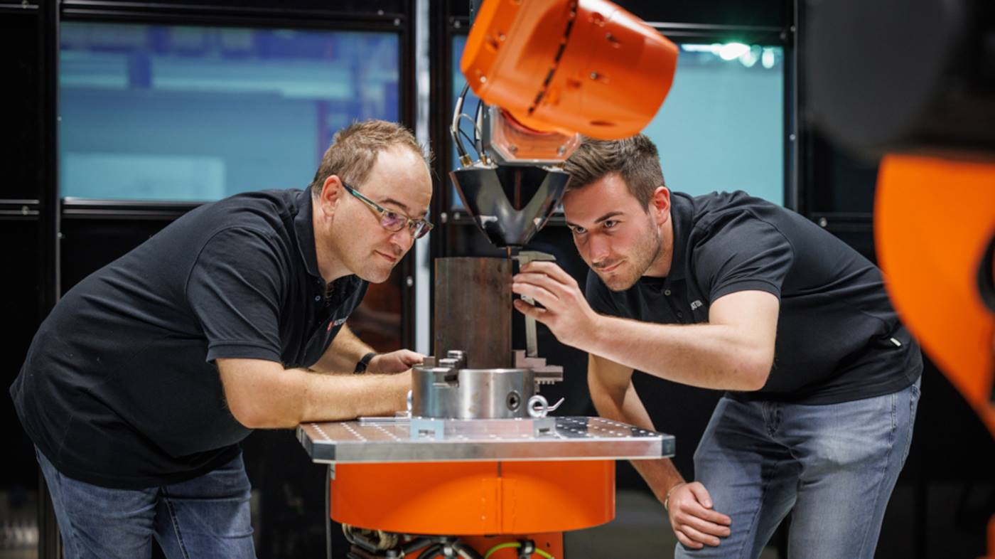 Geschäftsführer Marc Steidinger überprüft mit einem Mitarbeiter von HS Automation die Qualität des Metall-3D-Drucks.